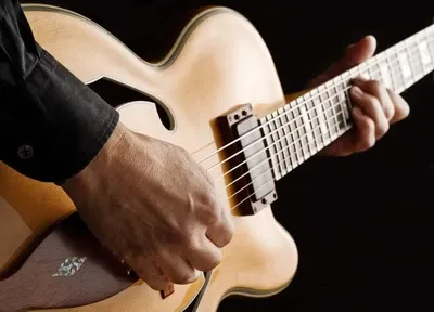 Closeup of man playing an acoustic guitar.